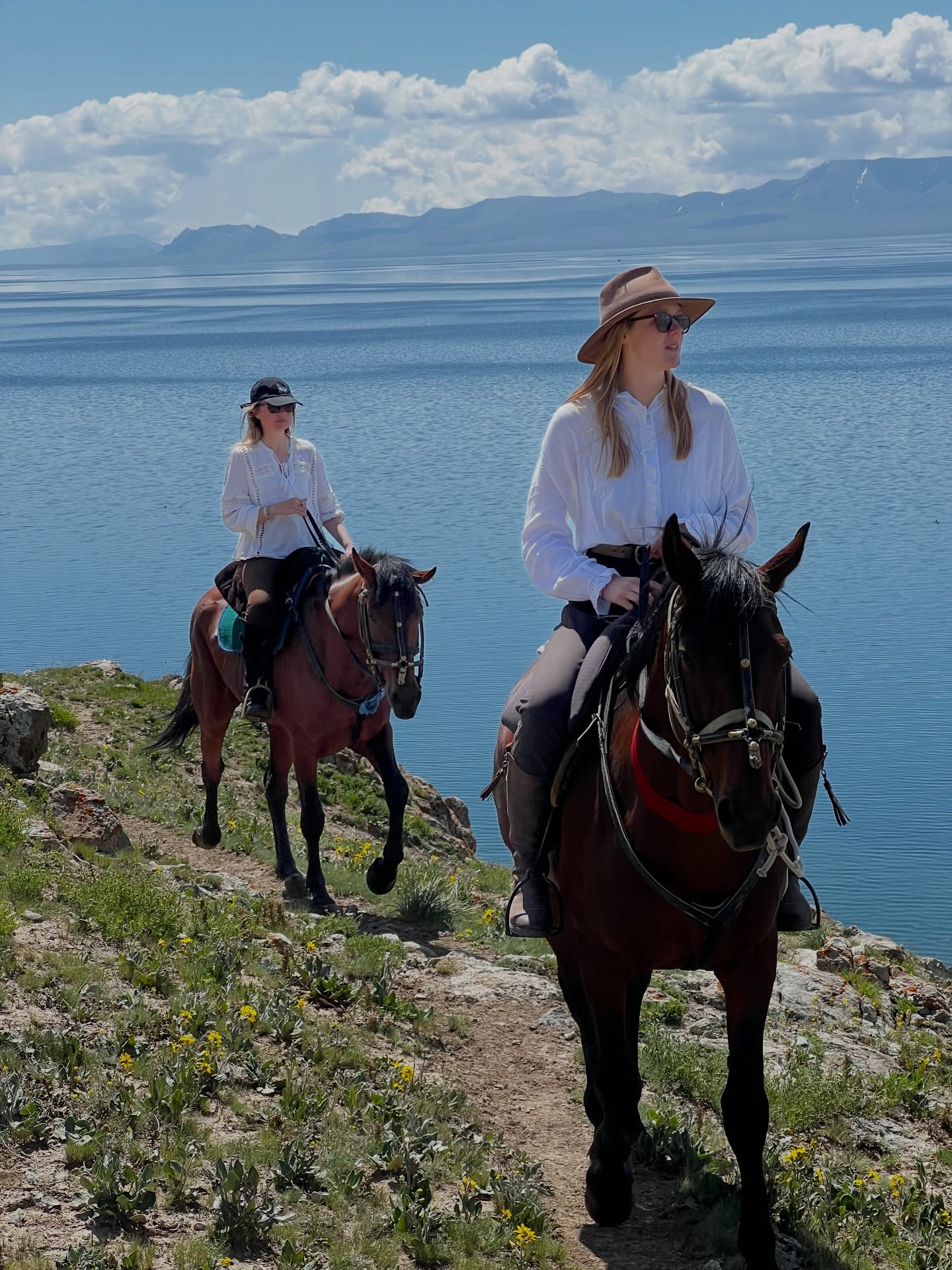Two riders on a trail above Song-Kol lake
